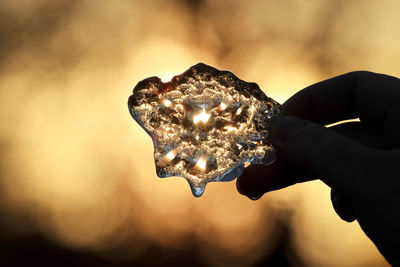 Close-up of hand holding illuminated lighting equipment