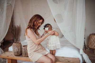 Rear view of mother and daughter at home