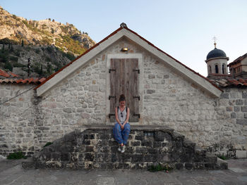 Full length portrait of a woman against building