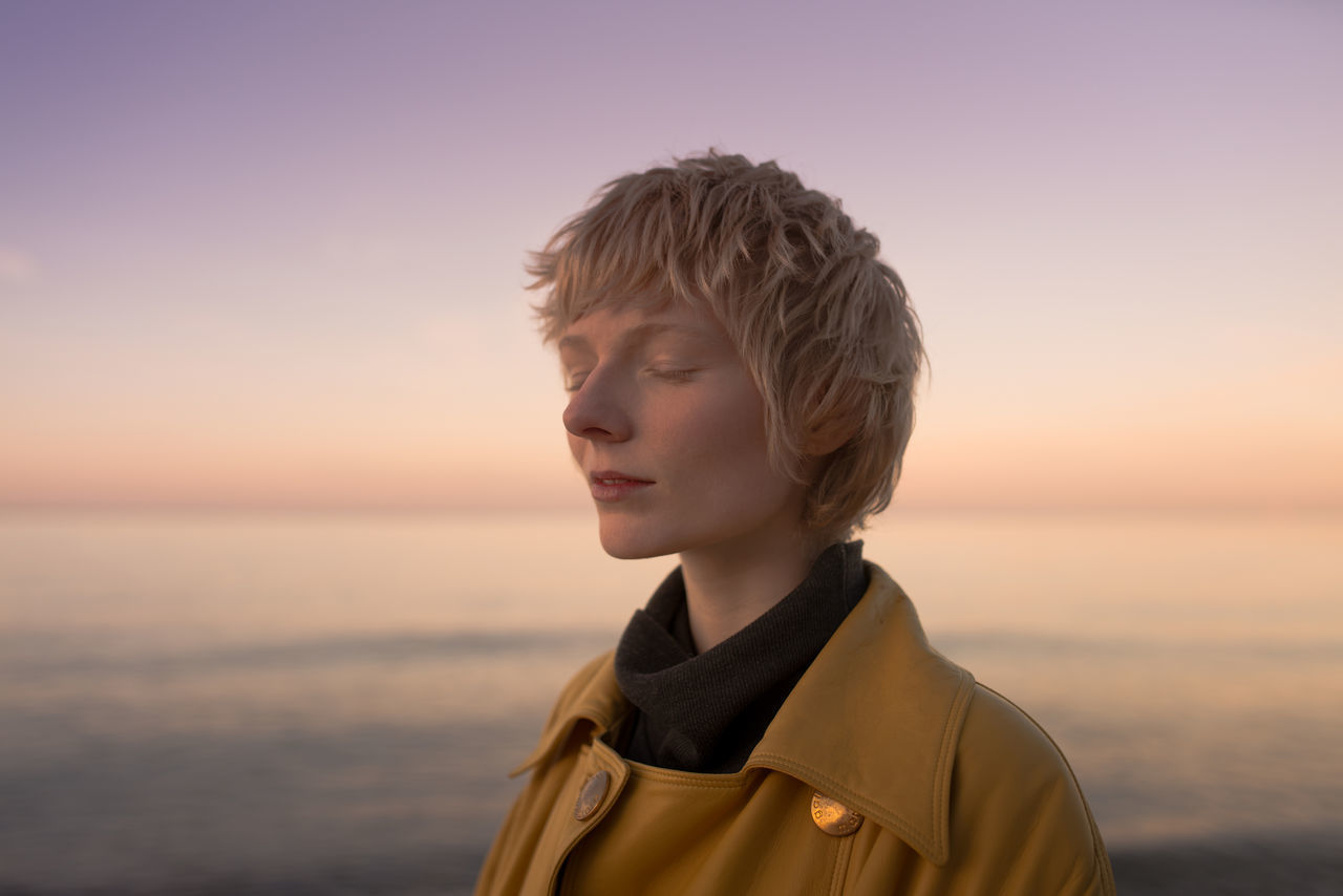 Portrait of young woman at beach during sunset