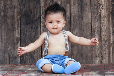 Portrait of cute baby boy on wood