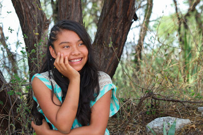 Portrait of smiling young woman in forest