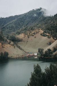 Scenic view of river by mountains against sky