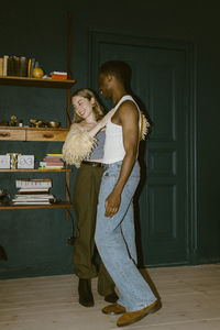 Happy multiracial young couple dancing with each other at home