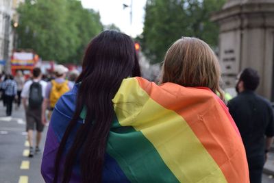 2 lady wrapped up in a pride flag