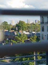 Houses and trees in city against sky