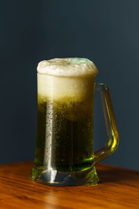 Close-up of beer glass on table against black background