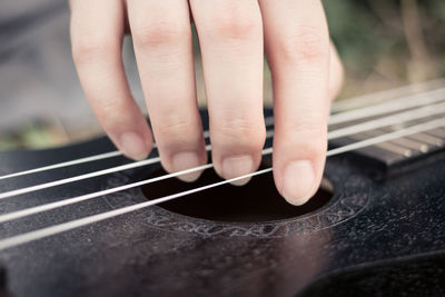 Cropped image of person playing guitar