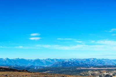 Scenic view of mountains against blue sky