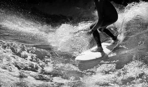 Low section of man splashing water in sea