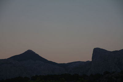 Silhouette mountain against sky at night