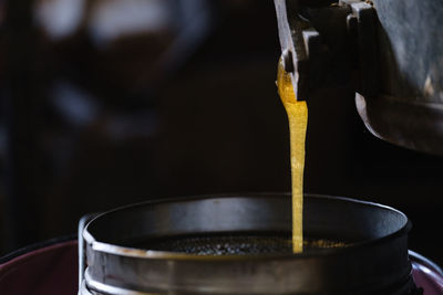 Honey dripping from the honey dipper into jar. close up. healthy organic coarse honey dipping 