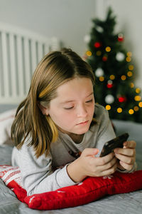 Portrait of young woman using mobile phone at home