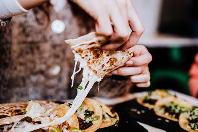 Close-up of hand holding pizza