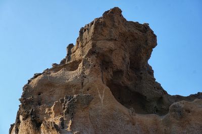 Low angle view of rock formation against sky