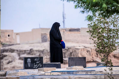 Full length of person in cemetery against sky