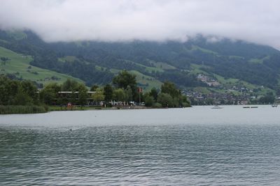 Scenic view of river by mountains against sky