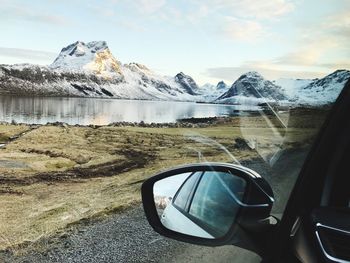 Close-up of car on side-view mirror against sky