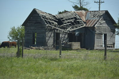 Abandoned house on field against sky