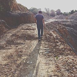 Rear view of man walking on road