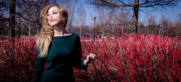 Portrait of a beautiful young woman standing on field