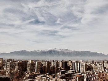 Cityscape against mountains during foggy weather