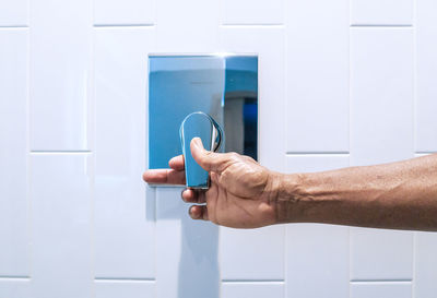 Close-up of hand holding white door