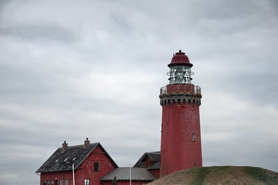 Lighthouse amidst buildings against sky