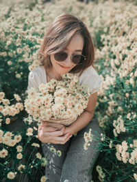 Midsection of woman holding flowering plants