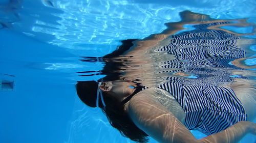 Side view of young woman swimming in pool