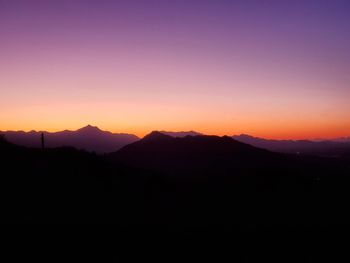 Scenic view of silhouette mountains against sky during sunset