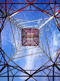 Low angle view of electricity pylon against blue sky