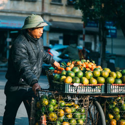Male street vendor with fruits on bicycle in city