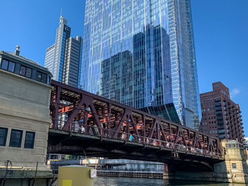 Low angle view of bridge and buildings against clear sky