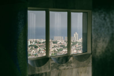 Close-up of glass window against building in city