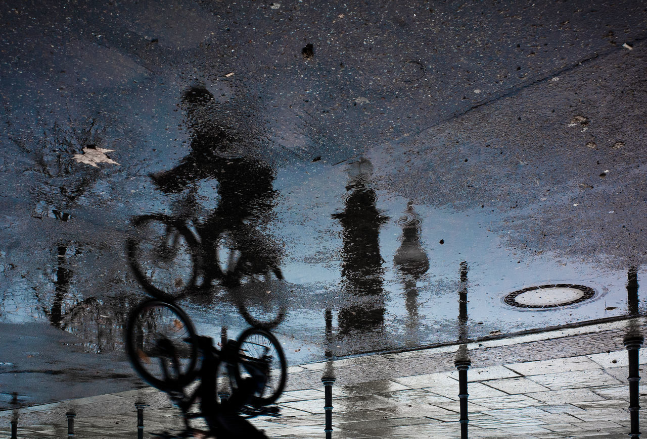 HIGH ANGLE VIEW OF WET ROAD IN PUDDLE