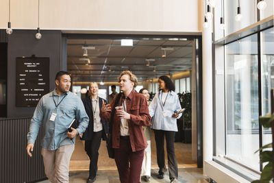 Male and female business delegates discussing while walking at convention center