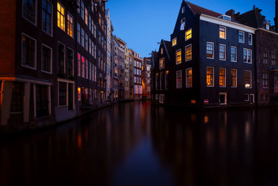 Canal amidst buildings against sky at night