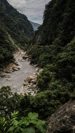 Scenic view of waterfall in forest against sky