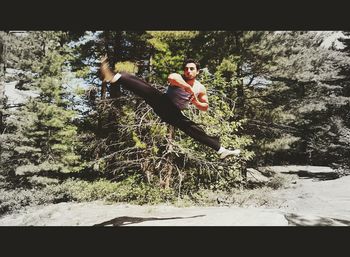 Young man jumping from tree