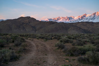 Scenic view of landscape against sky during sunset dirt road into desert