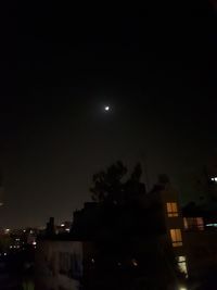 Low angle view of illuminated buildings against sky at night