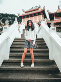 Full length portrait of teenage girl standing on steps