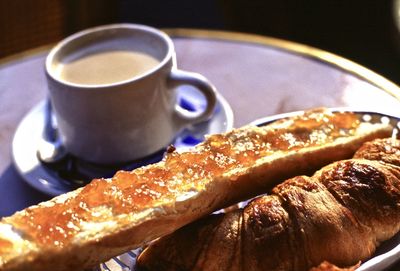 Morning breakfast - cafe au lait, croissant and french bread with butter and marmelade