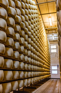 Full frame shot of patterned in building with shelves of parmesan cheese aged warehouse