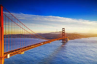 View of suspension bridge against cloudy sky