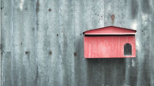 Close-up of red mailbox on wall