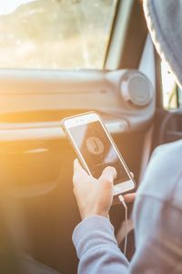 Midsection of man using mobile phone in train