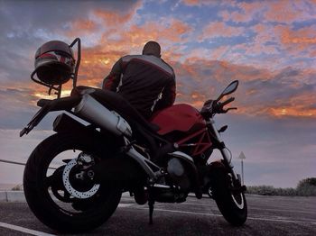 People on motorcycle against sky during sunset