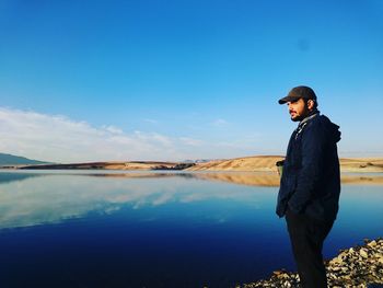 Man standing by calm lake